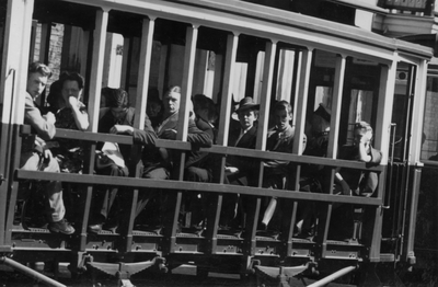 221145 Afbeelding van mensen in een zomerrijtuig van een tram, in de omgeving van, vermoedelijk, het Centraal Station ...